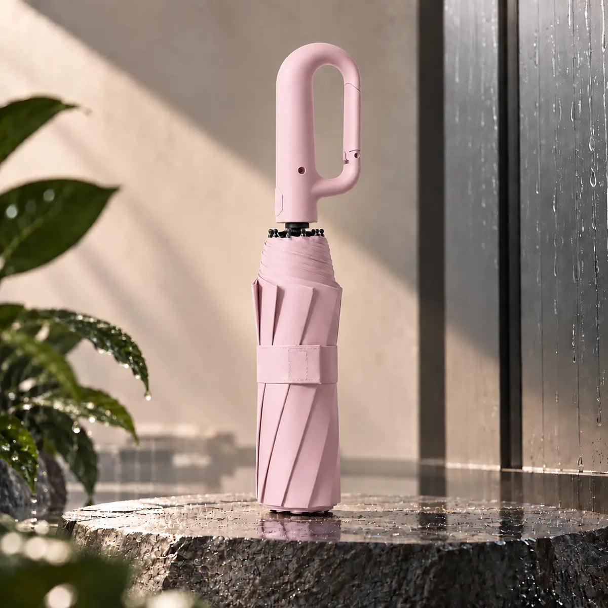 Brellova One in Pink, folded, standing on wet stone