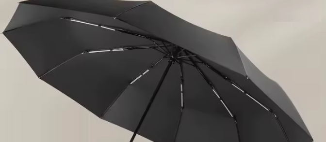 Open black umbrella seen from below, showing the ribs and the black inner canopy