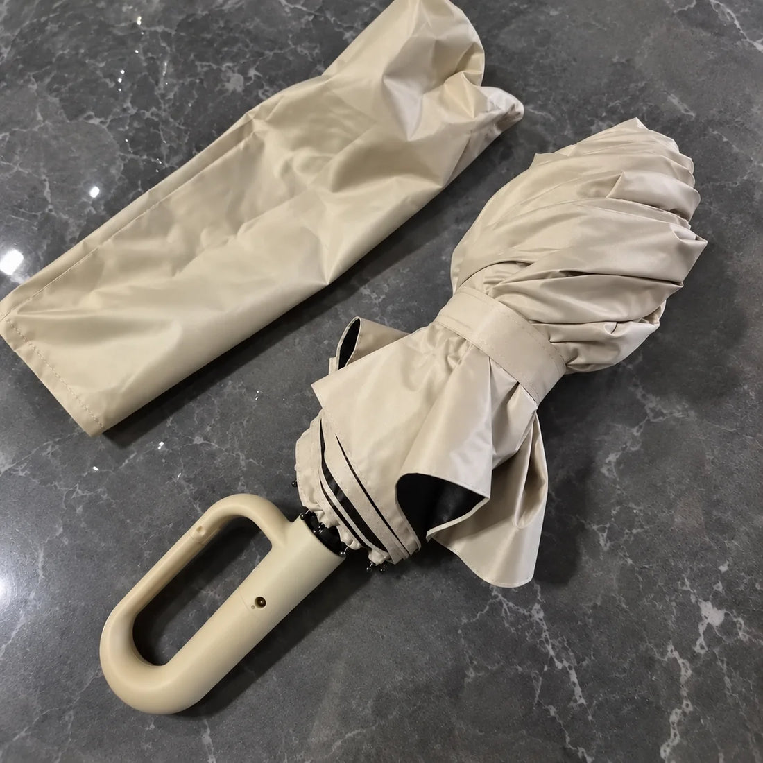 Beige Brellova One folded, next to its sleeve
