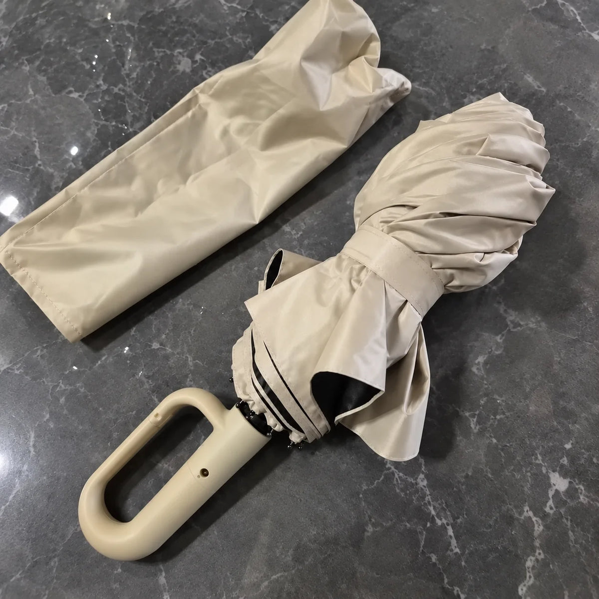 Beige Brellova One folded, next to its sleeve